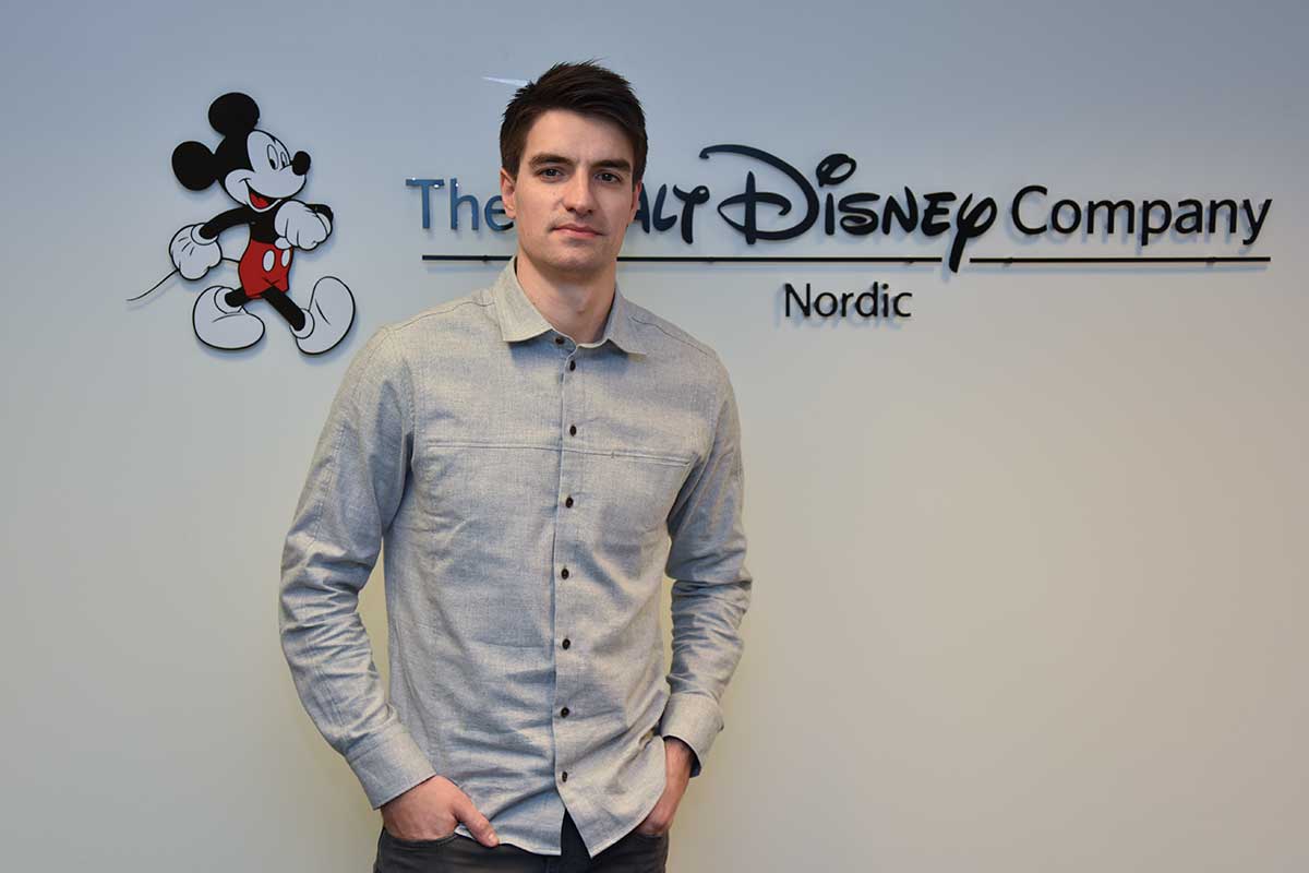 Ludvig Andreas Johansen mener den norske kinobransjen er «litt som en stor familie.» Her ved Disney-logoen på Skøyen-kontoret i Oslo i januar 2017. Foto: John Berge, KINOMAGASINET.no ©